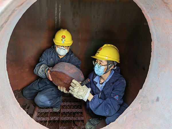 5月11日，動力車間三期工藝除氧器內(nèi)部，黨員突擊隊隊員劉瑞斌和李震正在清理舊填料.jpg